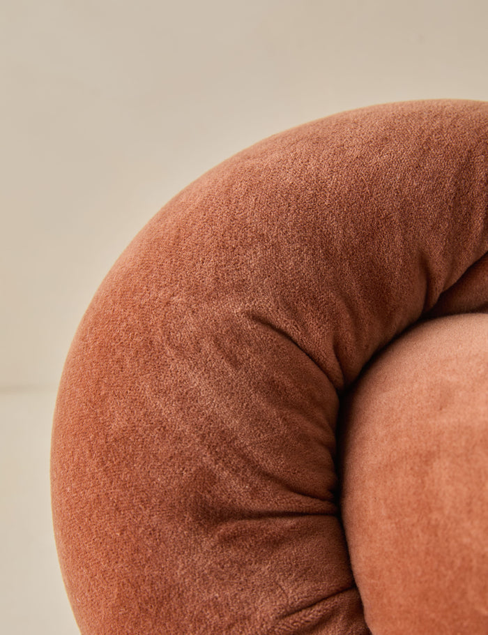 #color::burnt-orange | Close up of the Dewey velvet knot ball pillow.