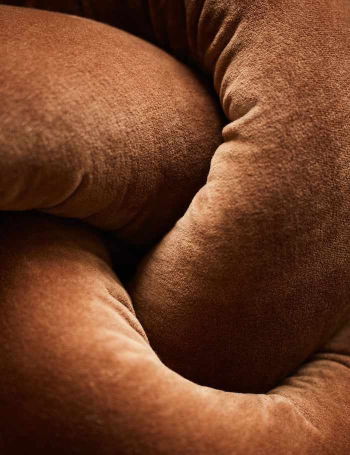 #color::burnt-orange | Close up of the Dewey velvet knot ball pillow.