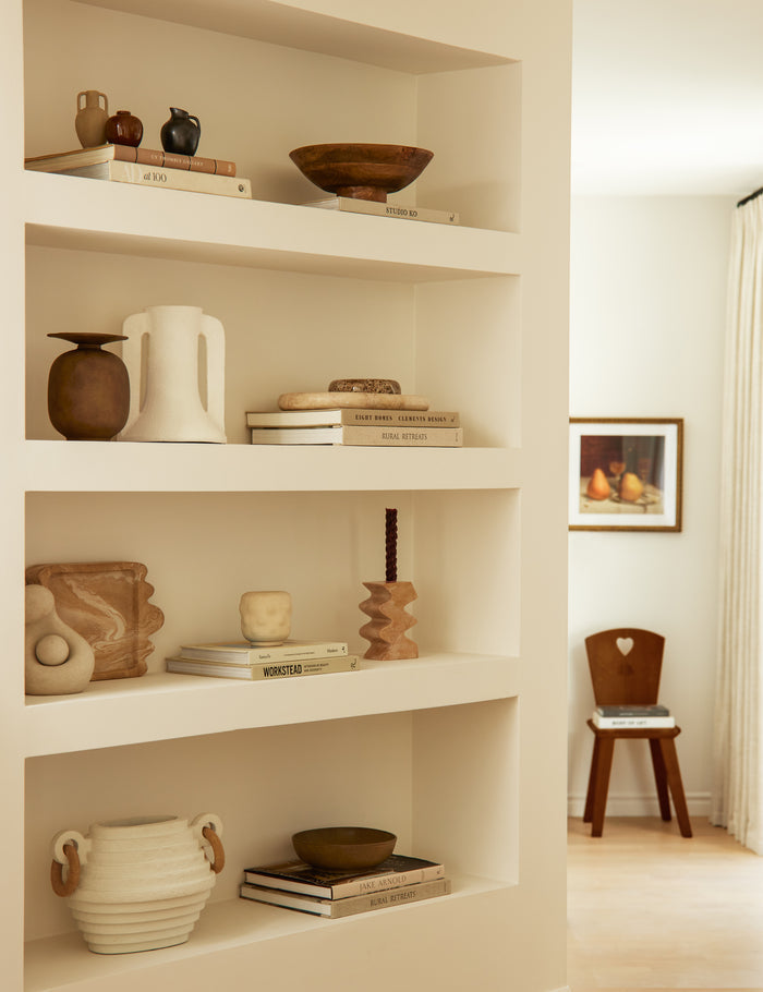 #color::travertine | Melona resin decorative tray styled on a built in bookshelf.