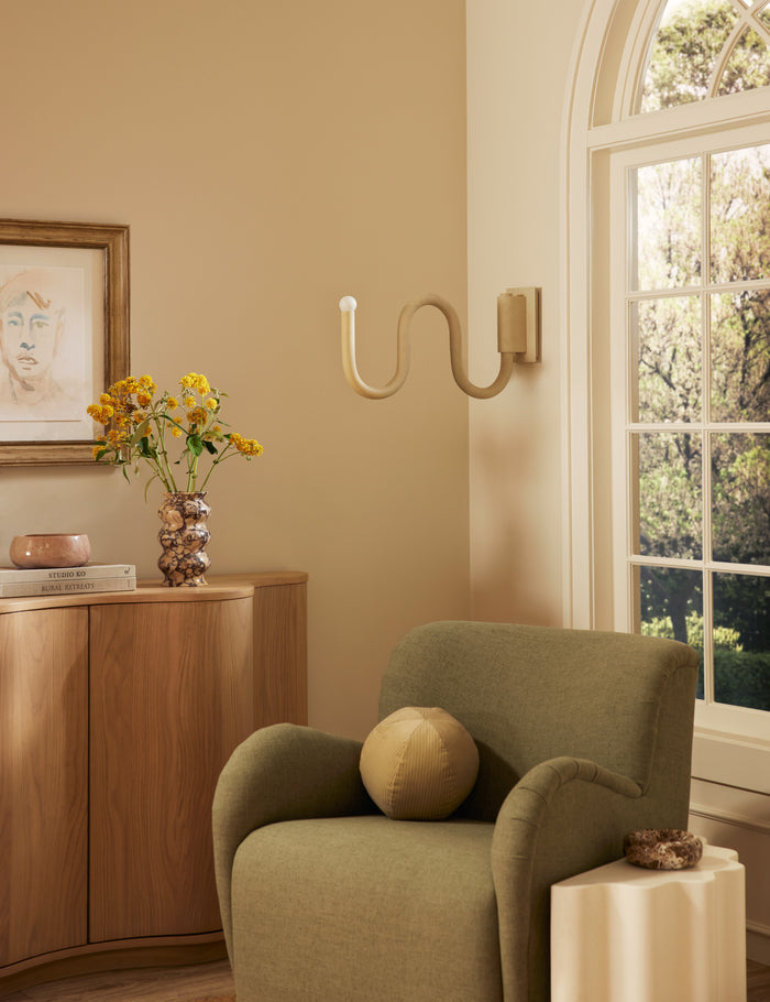 | Noor sculptural, wavy swing arm wall sconce styled in a living room
