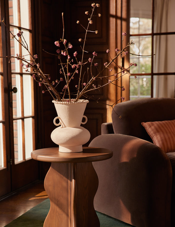 #color::buff #size::large | Philia wide beaded rim loop handle ceramic vase by Aimee Song styled on a side table next to a chaise lounge chair