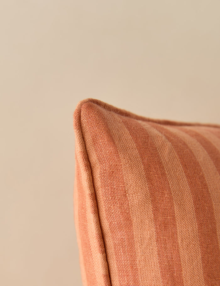 #style::square #style::lumbar #color::saffron | Close up view of the corner of the Welby striped tufted button linen throw pillow by Aimee Song